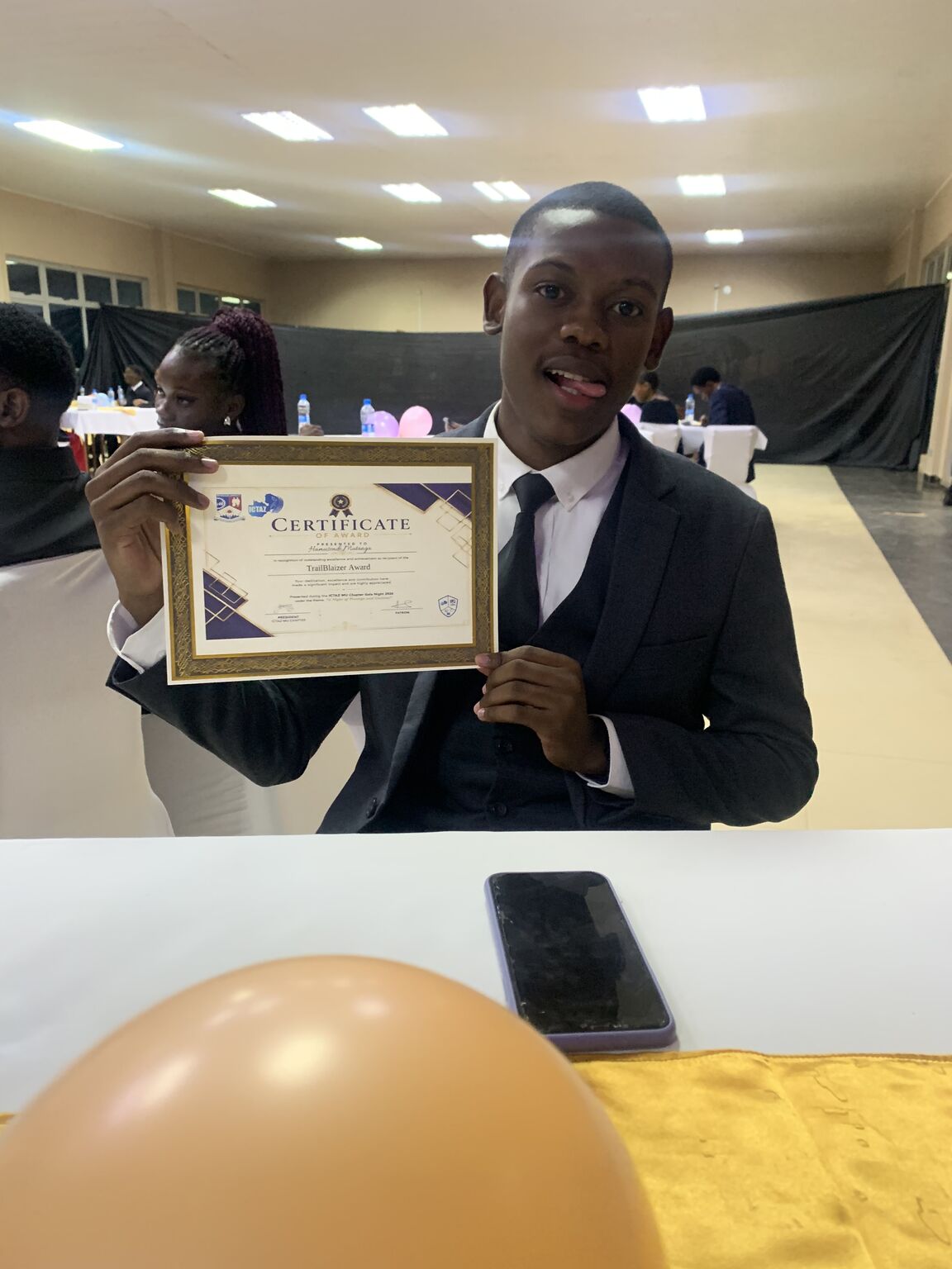 Hamusonde Muntanga holding his TrailBlaizer Award certificate